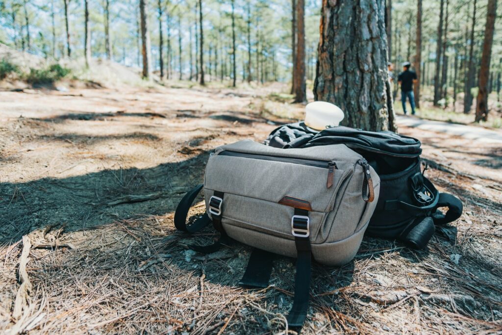 What to take glamping? Duffel bags sitting on forest ground.